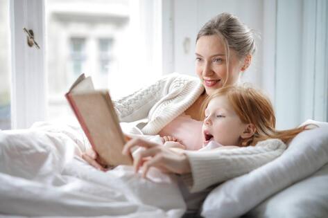 A woman reading to her daughter as a way to help kids cope with big life changes